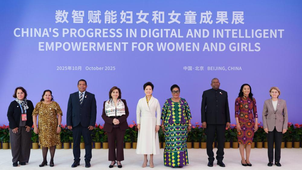 Peng Liyuan (C), wife of Chinese President Xi Jinping and UNESCO special envoy for the advancement of girls' and women's education, poses for a group photo with domestic and international guests during an exhibition showcasing China's progress in digital and intelligent empowerment for women and girls in Beijing, China, October 14, 2025. /Xinhua